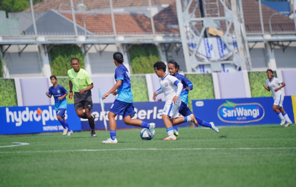 Arema FC Women (jersey putih) berhasil meredam perlawanan Akademi Persib Bandung (jersey biru) di laga perdana penyisihan Grub B U-18 Hydroplus Soccer League All-Stars 2025/2026 yang berlangsung di Supersoccer Arena, Kudus, Jawa Tengah, Senin (6/7/2026). 